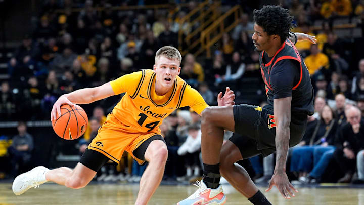 Iowa guard Bennett Stirtz (14) dribbles against Maryland forward Solomon Washington (9) Dec. 6, 2025 at Carver-Hawkeye Arena in Iowa City, Iowa.