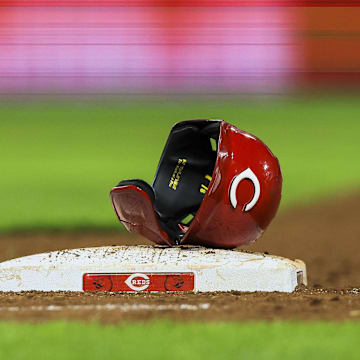 Jul 29, 2024; Cincinnati, Ohio, USA; The helmet and sliding glove of Cincinnati Reds catcher Tyler Stephenson (not pictured) sits on first base during a stop in play in the eighth inning in the game against the Chicago Cubs at Great American Ball Park. Mandatory Credit: Katie Stratman-Imagn Images