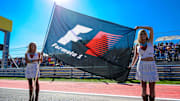 Nov 18, 2012; Austin, TX, USA; Two Formula One grid girls hold up a F1 flag before the start of the United States Grand Prix at the Circuit of the Americas. Mandatory Credit: Jerome Miron-Imagn Images