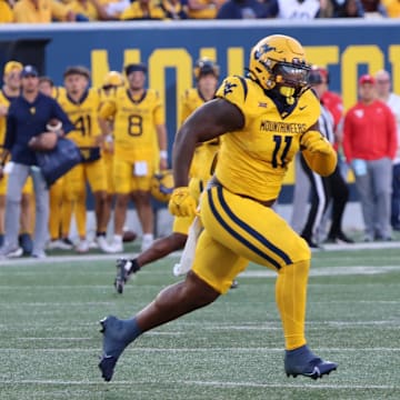 West Virginia University defensive lineman TJ Jackson chases down University at Albany quarterback Myles Burkett.