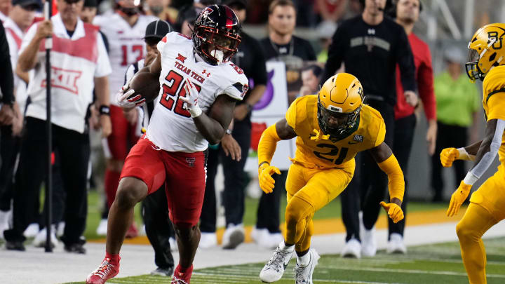 Oct 7, 2023; Waco, Texas, USA;  Texas Tech Red Raiders running back Bryson Donnell (22) runs the ball against Baylor Bears cornerback Chateau Reed (21) during the first half at McLane Stadium. Mandatory Credit: Chris Jones-USA TODAY Sports