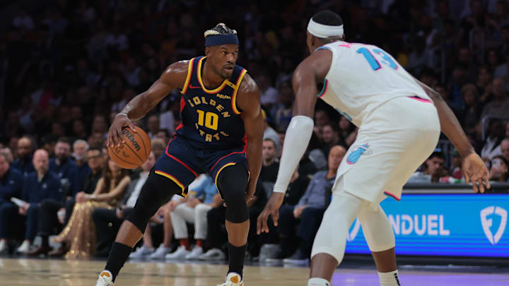 Mar 25, 2025; Miami, Florida, USA; Golden State Warriors forward Jimmy Butler III (10) dribbles the basketball as Miami Heat center Bam Adebayo (13) defends during the first quarter at Kaseya Center. Mandatory Credit: Sam Navarro-Imagn Images