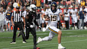 Nov 1, 2025; Houston, Texas, USA; West Virginia Mountaineers quarterback Scotty Fox Jr. (15) rushes for a touchdown against tHouston Cougars linebacker Corey Platt Jr. (9)  in the second half at TDECU Stadium. Mandatory Credit: Thomas Shea-Imagn Images