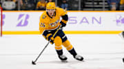 Nov 9, 2024; Nashville, Tennessee, USA;  Nashville Predators center Philip Tomasino (26) skates with the puck against against the Utah Hockey Club during the third period at Bridgestone Arena. Mandatory Credit: Steve Roberts-Imagn Images