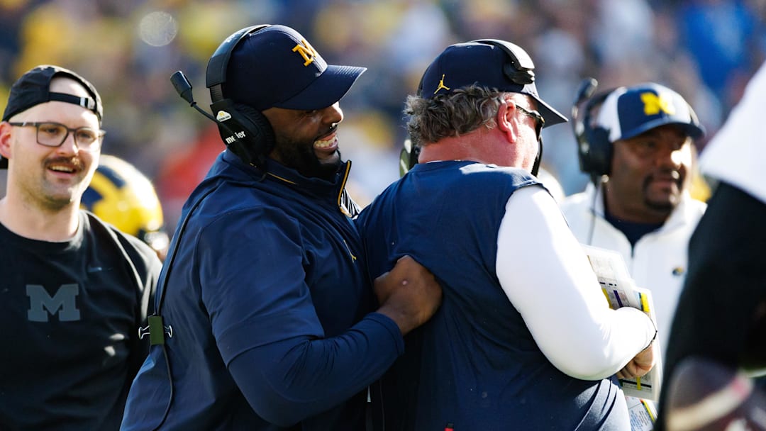 Dec 31, 2024; Tampa, FL, USA; Michigan Wolverines head coach Sherrone Moore smiles while joking with a defensive coach against the Alabama Crimson Tide during the second half at Raymond James Stadium. Mandatory Credit: Matt Pendleton-Imagn Images