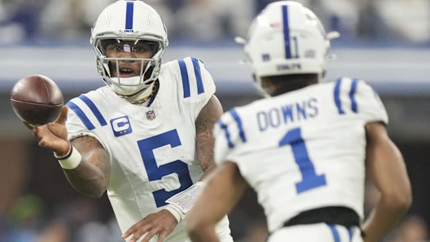 Colts quarterback Anthony Richardson (all-white uniform) tries to throw a short pass to wide receiver Josh Downs.
