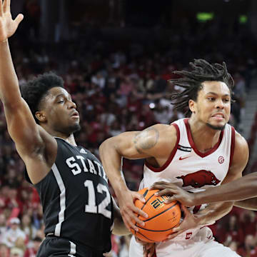 Arkansas Razorbacks guard D.J. Wagner (21) drives between Mississippi State Bulldogs guard Josh Hubbard (12) and forward KeShawn Murphy (3) during the first half at Bud Walton Arena in Fayetteville, Ark.