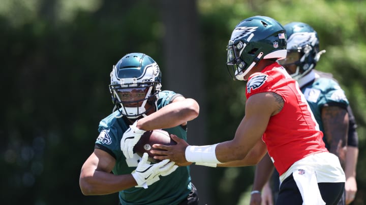 May 30, 2024; Philadelphia, PA, USA; Philadelphia Eagles quarterback Jalen Hurts (1) hands off to running back Saquon Barkley (26) during practice at NovaCare Complex. 