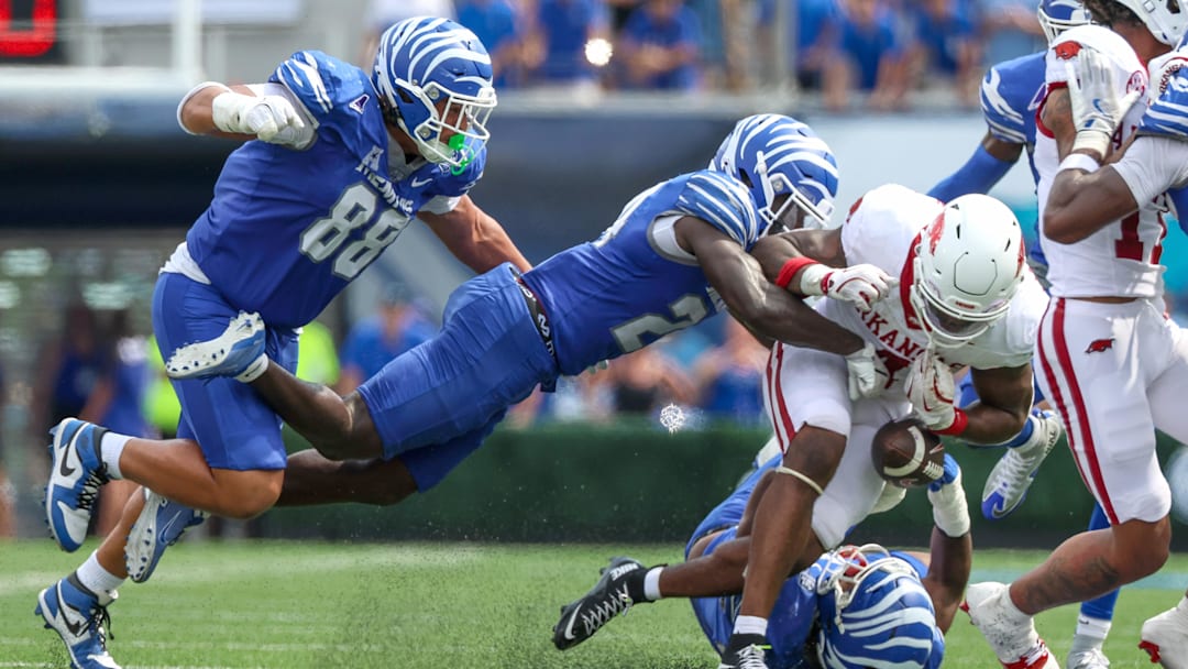 Sep 20, 2025; Memphis, Tennessee, USA; Memphis Tigers defensive back Kamari Wilson (24) forces a fumble against Arkansas Razorbacks running back Mike Washington Jr. (4) during the second half at Simmons Bank Liberty Stadium. Mandatory Credit: Wesley Hale-Imagn Images
