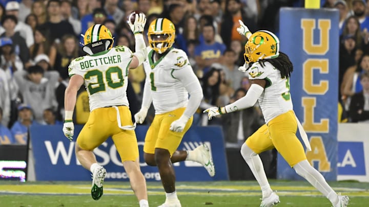 Sep 28, 2024; Pasadena, California, USA; Oregon Ducks linebacker Dylan Williams (20) celebrates intercepting a pass in the second quarter against the UCLA Bruins at Rose Bowl. Right is Oregon Ducks defensive end Jordan Burch (1) and Oregon Ducks defensive back Brandon Johnson (3). Mandatory Credit: Robert Hanashiro-Imagn Images