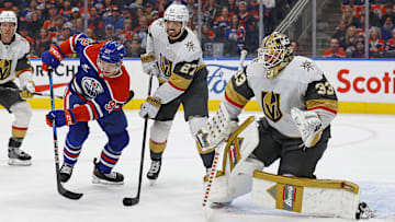 Dec 14, 2024; Edmonton, Alberta, CAN; Edmonton Oilers forward Vasily Podkolzin (92) and Vegas Golden Knights defensemen Shea Theodore (27) look for a loose puck in front of  goaltender Adin Hill (33) during the third period at Rogers Place. Mandatory Credit: Perry Nelson-Imagn Images