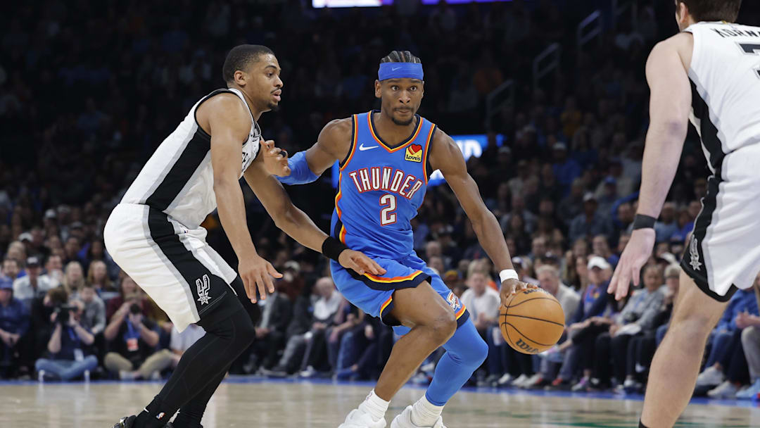Jan 13, 2026; Oklahoma City, Oklahoma, USA; Oklahoma City Thunder guard Shai Gilgeous-Alexander (2) drives down the court past San Antonio Spurs forward/guard Keldon Johnson (3) during the second half at Paycom Center. Mandatory Credit: Alonzo Adams-Imagn Images