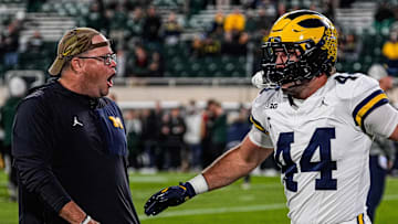 Michigan tight end Max Bredeson shakes hands with tight ends coach Steve Casula during warmups at Spartan Stadium in East Lansing on Saturday, October 25, 2025.