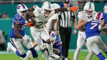 Miami Dolphins running back Jeff Wilson Jr. (23), leaps through a tackle against the Buffalo Bills NFL football game Jan 07, 2024, in Miami Gardens.