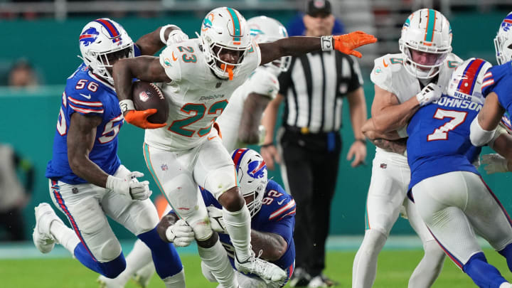 Miami Dolphins running back Jeff Wilson Jr. (23), leaps through a tackle against the Buffalo Bills NFL football game Jan 07, 2024, in Miami Gardens.