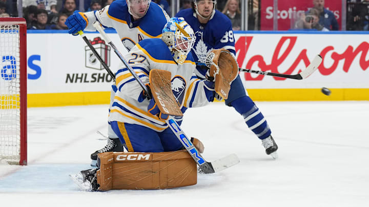 Dec 15, 2024; Toronto, Ontario, CAN; Buffalo Sabres goaltender Devon Levi (27) tries to stop a puck against the Toronto Maple Leafs during the third period at Scotiabank Arena. Mandatory Credit: Nick Turchiaro-Imagn Images
