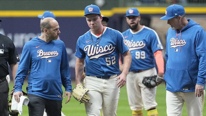 Apr 11, 2026; Milwaukee, Wisconsin, USA; Milwaukee Brewers pitcher Kyle Harrison (52) is evaluated by Milwaukee Brewers trainer, left and Milwaukee Brewers pitching coach Chris Hook (84), right after getting tangled up with Washington Nationals left fielder James Wood (29) in the first inning at American Family Field. Mandatory Credit: Michael McLoone-Imagn Images