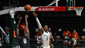 Dec 19, 2020; Coral Gables, Florida, USA; Jacksonville Dolphins forward Dontarius James (0) shoots the ball over Miami Hurricanes forward Anthony Walker (1) during the first half at Watsco Center. Mandatory Credit: Jasen Vinlove-Imagn Images