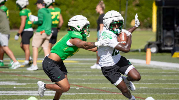 Oregon wide receiver Jurrion Dickey carries the ball under cover from defensive back Kobe Savage