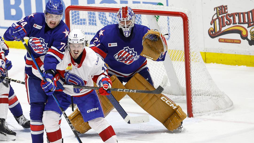 Amerks Nikita Novikov tries to clear out Laval’s Rafael Harvey-Pinard from in front of goalie Devon Levi.