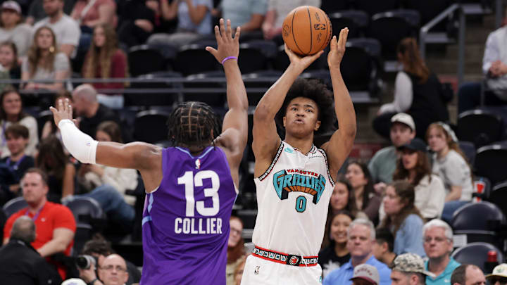 Mar 25, 2025; Salt Lake City, Utah, USA;  Memphis Grizzlies forward Jaylen Wells (0) shoots the ball over Utah Jazz guard Isaiah Collier (13) during the second half at Delta Center. Mandatory Credit: Chris Nicoll-Imagn Images