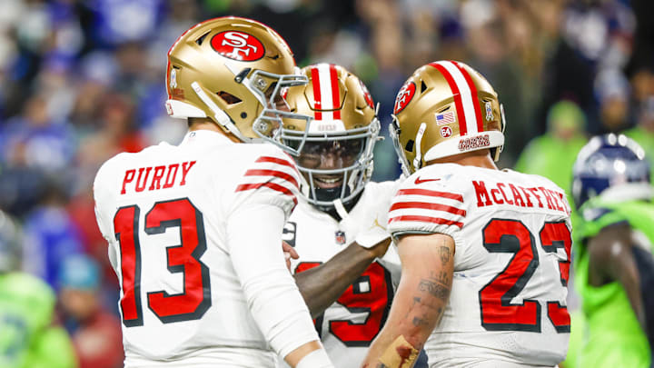 San Francisco 49ers running back Christian McCaffrey (23) celebrates with quarterback Brock Purdy (13) and wide receiver Deebo Samuel.