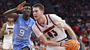 Jan 1, 2025; Louisville, Kentucky, USA;  Louisville Cardinals forward Noah Waterman (93) drives to the basket against North Carolina Tar Heels guard Drake Powell (9) during the second half at KFC Yum! Center. 