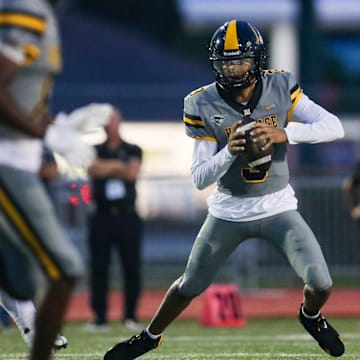 American Heritage Patriots quarterback Dia Bell (3) scrambles in the backfield during the first quarter of a game against the Naples Golden Eagles at Staver Field in Naples on Friday, Sept. 13, 2024.
