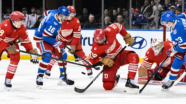 Nov 16, 2025; New York, New York, USA; Detroit Red Wings defenseman Travis Hamonic (52) tries to gain control of the puck against New York Rangers center Vincent Trocheck (16) during the third period at Madison Square Garden. Mandatory Credit: John Jones-Imagn Images
