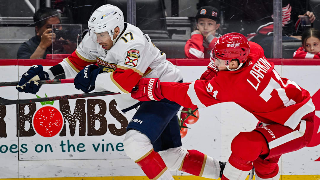 Apr 6, 2025; Detroit, Michigan, USA; Florida Panthers center Evan Rodrigues (17) and Detroit Red Wings center Dylan Larkin (71) battle for the puck during the first period at Little Caesars Arena. Mandatory Credit: Tim Fuller-Imagn Images