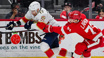 Apr 6, 2025; Detroit, Michigan, USA; Florida Panthers center Evan Rodrigues (17) and Detroit Red Wings center Dylan Larkin (71) battle for the puck during the first period at Little Caesars Arena. Mandatory Credit: Tim Fuller-Imagn Images