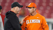 Louisville football coach Jeff Brohm and Clemson Tigers head coach Dabo Swinney talk before the game against Clemson at L&N Stadium.