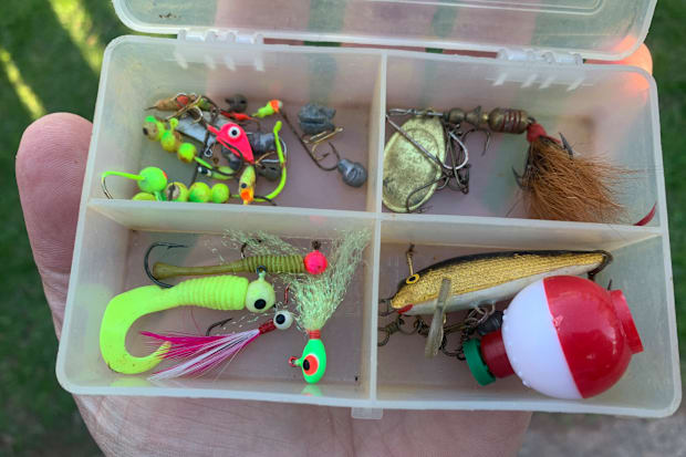 A small tackle box with an assortment of small hooks and lures.