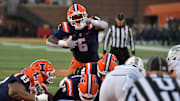 Nov 16, 2024; Champaign, Illinois, USA; Illinois Fighting Illini running back Josh McCray (6) leaps over the pile for a touchdown against the Michigan State Spartans during the second half at Memorial Stadium. Mandatory Credit: Ron Johnson-Imagn Images