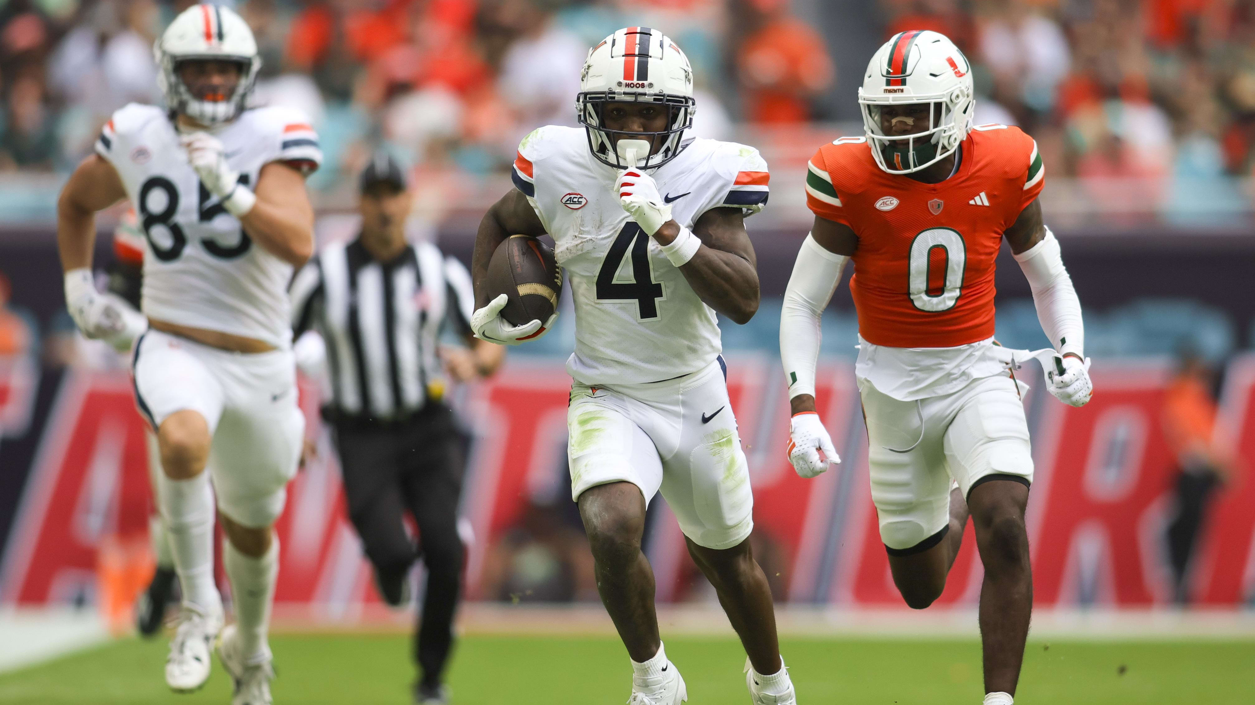 Virginia Cavaliers wide receiver Malik Washington (4) outruns Miami Hurricane defenders.