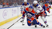 Nov 23, 2024; Edmonton, Alberta, CAN; New York Rangers defensemen Ryan Lindgren (55) cross-checks Edmonton Oilers forward Drake Caggiula (8) during the third period at Rogers Place. Mandatory Credit: Perry Nelson-Imagn Images
