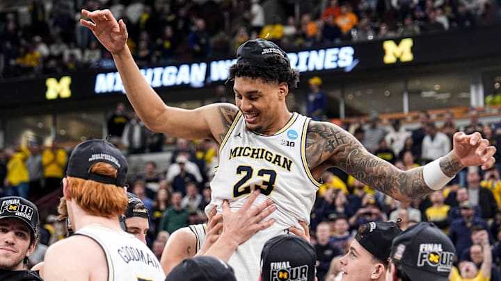 Michigan players pick up forward Yaxel Lendeborg (23) to celebrate winning the NCAA Tournament Midwest Regional Championship trophy after 95-62 win over Tennessee at United Center in Chicago on Sunday, March 29, 2026.
