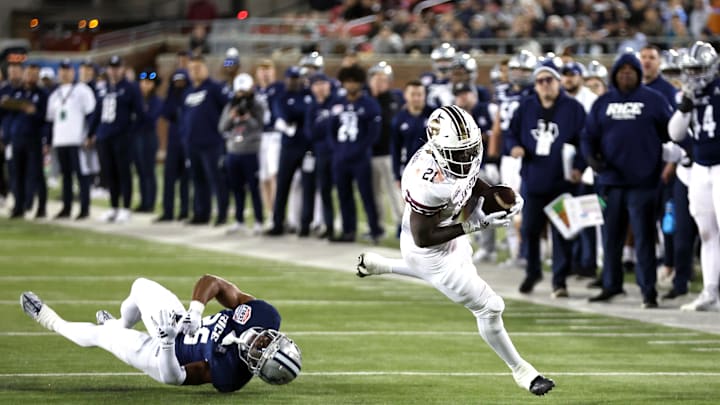 Dec 26, 2023; Dallas, TX, USA; Texas State Bobcats running back Ismail Mahdi (21) runs with the ball against Rice Owls defensive back AJ Stephens (25) in the second quarter at Gerald J Ford Stadium. Mandatory Credit: Tim Heitman-Imagn Images