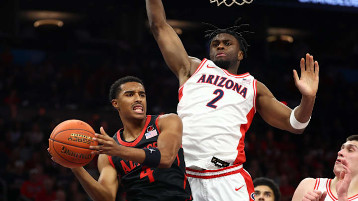 Dec 20, 2025; Phoenix, Arizona, USA; San Diego State Aztecs guard Sean Newman Jr. (4) passes the ball against Arizona Wildcats forward Dwayne Aristode (2) in the first half during the Hall of Fame Series at Mortgage Matchup Center. Mandatory Credit: Mark J. Rebilas-Imagn Images