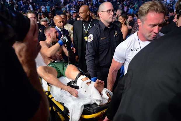 Conor McGregor is carried off a stretcher following an injury suffered against Dustin Poirier during UFC 264 at T-Mobile Aren