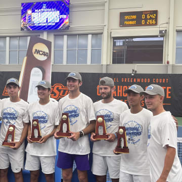 The TCU men's tennis team hoists the national championship trophy after defeating Texas 4-3. 