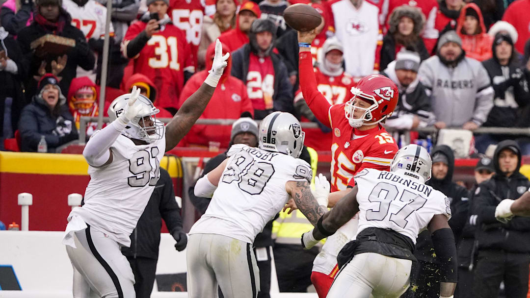 Dec 25, 2023; Kansas City, Missouri, USA; Kansas City Chiefs quarterback Patrick Mahomes (15) throws a pass as he   s pressured by Las Vegas Raiders defensive tackle Bilal Nichols (91) and defensive end Maxx Crosby (98) and defensive end Janarius Robinson (97) during the game at GEHA Field at Arrowhead Stadium. Mandatory Credit: Denny Medley-Imagn Images