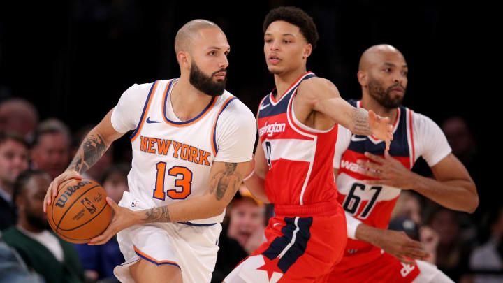 Oct 18, 2023; New York, New York, USA; New York Knicks guard Evan Fournier (13) controls the ball against Washington Wizards guard Ryan Rollins (9) and forward Taj Gibson (67) during the fourth quarter at Madison Square Garden. Mandatory Credit: Brad Penner-USA TODAY Sports