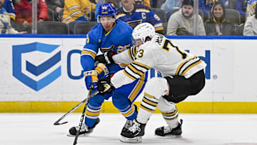 Jan 13, 2024; St. Louis, Missouri, USA;  St. Louis Blues center Jordan Kyrou (25) and Boston Bruins defenseman Charlie McAvoy (73) battle for the puck during the second period at Enterprise Center. Mandatory Credit: Jeff Curry-Imagn Images