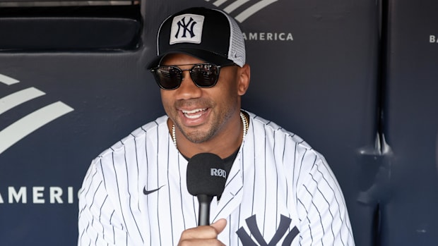 New York Giants quarterback Russell Wilson is interviewed prior to a game between the New York Mets and the New York Yankees.