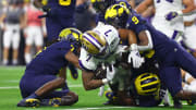 Jan 8, 2024; Houston, TX, USA; Washington Huskies running back Dillon Johnson (7) is tackled by Michigan Wolverines defensive back Makari Paige (7) and defensive back Rod Moore (right) during the second quarter in the 2024 College Football Playoff national championship game at NRG Stadium. Mandatory Credit: Mark J. Rebilas-USA TODAY Sports