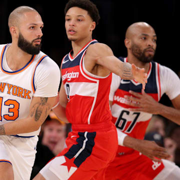 Oct 18, 2023; New York, New York, USA; New York Knicks guard Evan Fournier (13) controls the ball against Washington Wizards guard Ryan Rollins (9) and forward Taj Gibson (67) during the fourth quarter at Madison Square Garden. Mandatory Credit: Brad Penner-Imagn Images