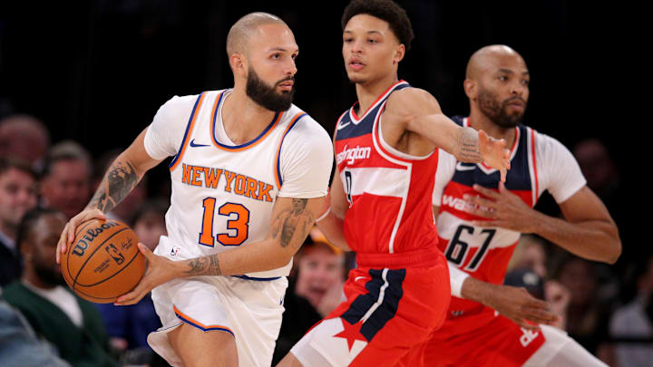 Oct 18, 2023; New York, New York, USA; New York Knicks guard Evan Fournier (13) controls the ball against Washington Wizards guard Ryan Rollins (9) and forward Taj Gibson (67) during the fourth quarter at Madison Square Garden. Mandatory Credit: Brad Penner-Imagn Images