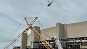 A helicopter helps set up new lights and take down old lights at Camp Randall Stadium on Friday.