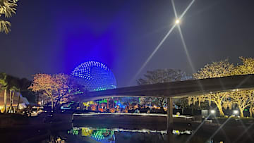 EPCOT'S Spaceship Earth glows blue under a full moon. Image courtesy Brian Miller
